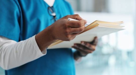 A healthcare employee holding a folder containing medical records. | Haight Stang, LLC